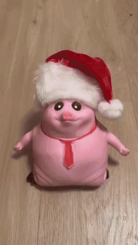 A Person Is Petting A Pink Pig Wearing A Santa Hat And Tie GIF