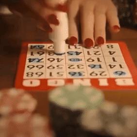 A Person Is Playing A Game Of Bingo With Numbers On A Board GIF
