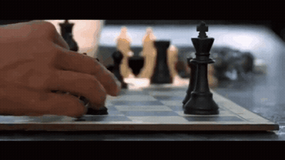 A Person Is Playing A Game Of Chess And Moving A Piece On The Board . GIF