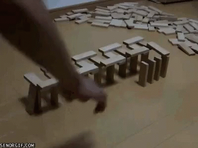 A Person Is Playing A Game Of Dominoes On A Wooden Floor GIF