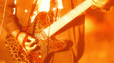A Person Is Playing A Guitar With A Leopard Print GIF