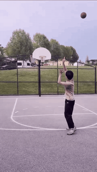 A Person Is Playing Basketball On A Court With A Basketball Hoop In The Background GIF