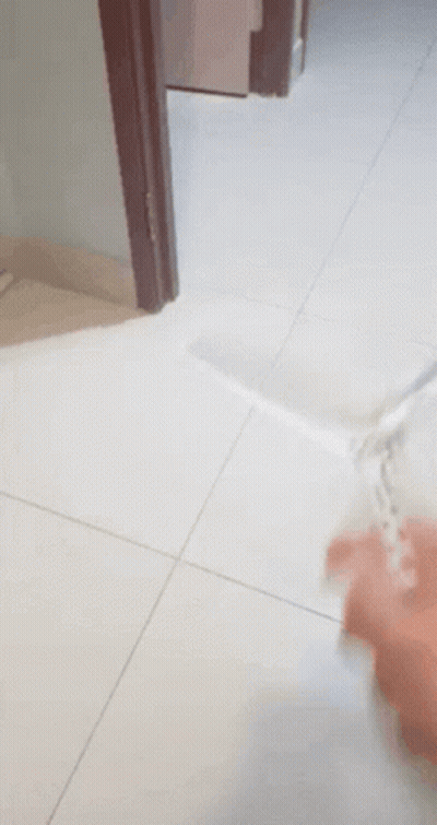 A Person Is Playing With A Toy On A Tile Floor GIF