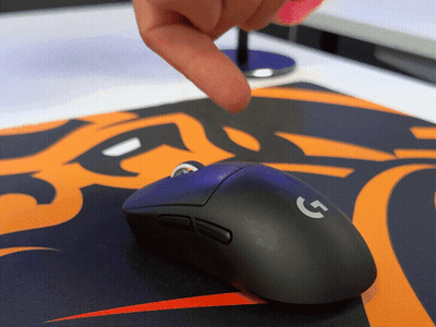 A Person Is Pointing At A Black Logitech Mouse GIF