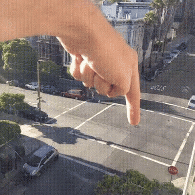 A Person Is Pointing At A Stop Sign GIF