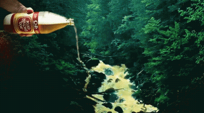 A Person Is Pouring A Bottle Of Dr Pepper Into A Stream GIF