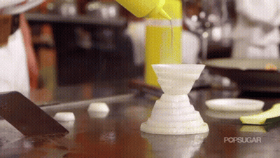 A Person Is Pouring A Yellow Liquid Into A White Container With The Word Popsugar On The Bottom GIF