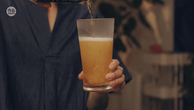 A Person Is Pouring Beer Into A Glass With A Sticker That Says ' Taiwanese ' On It GIF
