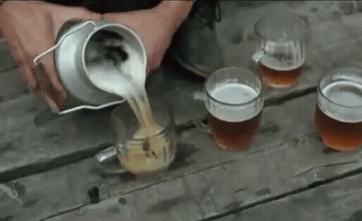 A Person Is Pouring Beer Into Four Mugs On A Wooden Table GIF