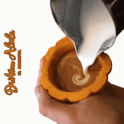 A Person Is Pouring Milk Into A Pumpkin Shaped Cup With The Name Dritan Alicha Written On The Bottom GIF