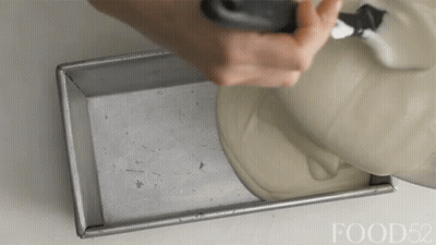 A Person Is Pouring Something Into A Pan With The Words Food52 Visible GIF