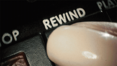 A Person Is Pressing A Button That Says Rewind On It GIF