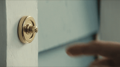 A Person Is Pressing A Doorbell On A Door GIF