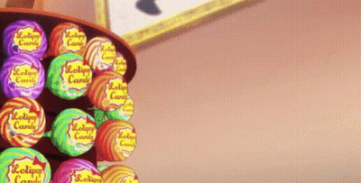 A Person Is Reaching For A Lollipop In A Display Of Lollipop Candy GIF