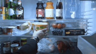 A Person Is Reaching Into A Fridge With A Hamilton Cheese Box On The Bottom Shelf GIF