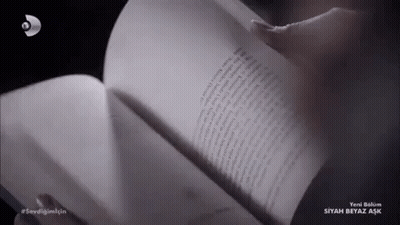 A Person Is Reading A Book With The Word Siyah Beyaz Aşk On The Bottom Right GIF