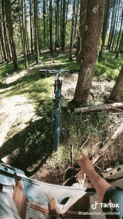 A Person Is Riding A Bike In The Woods With A Tiktok Watermark On The Bottom GIF