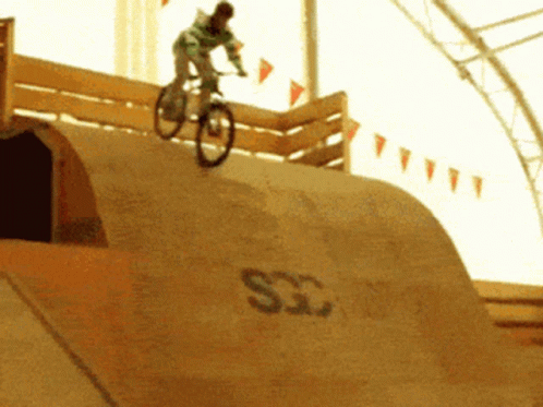A Person Is Riding A Bike On A Ramp That Says Sg GIF