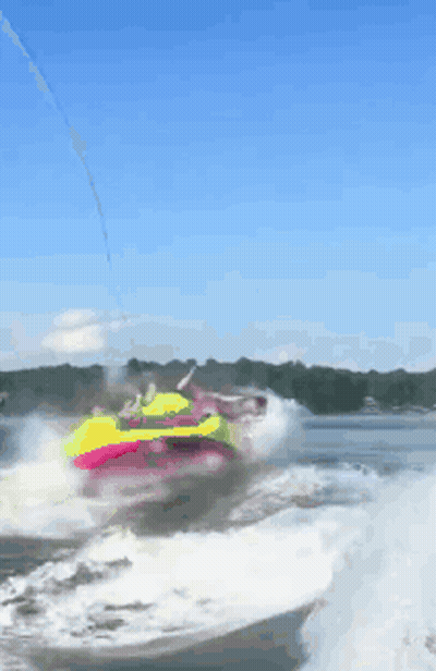 A Person Is Riding A Colorful Raft In The Water GIF