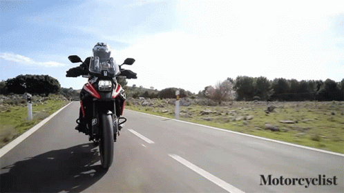 A Person Is Riding A Motorcycle Down A Road With The Words Motorcyclist Below It GIF