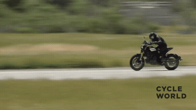 A Person Is Riding A Motorcycle On A Road With The Words Cycle World Written On The Bottom GIF