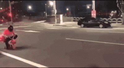 A Person Is Riding A Motorcycle On A Street At Night . GIF