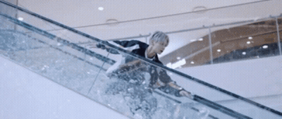 A Person Is Riding An Escalator In A Mall GIF