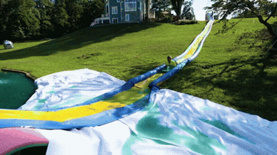 A Person Is Riding Down A Giant Water Slide GIF