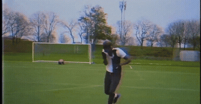A Person Is Running On A Soccer Field With A Goal In The Background . GIF