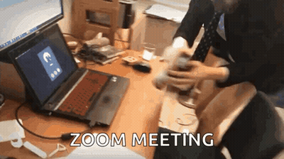 A Person Is Sitting At A Desk With A Laptop On It And The Words Zoom Meeting Written On The Screen . GIF