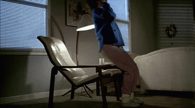 A Person Is Sitting In A Chair In A Living Room GIF