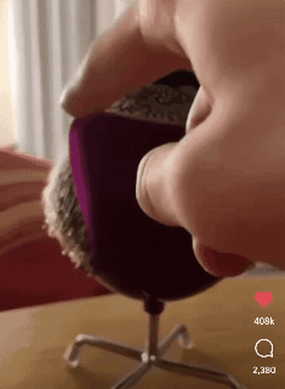 A Person Is Sitting In A Chair With A Purple Cushion On It And The Number 398K On The Bottom Right GIF
