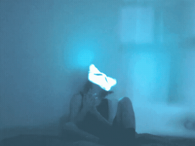 A Person Is Sitting In A Dark Room With A Cat Mask On Their Face GIF