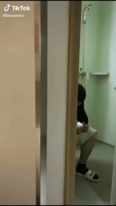 A Person Is Sitting On A Toilet In A Bathroom With A Tik Tok Watermark GIF