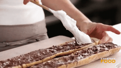 A Person Is Spreading Chocolate On A Piece Of Bread With Everyday Food Written On The Bottom Right GIF