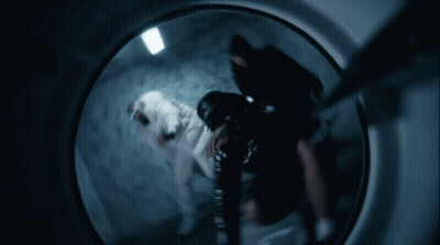 A Person Is Standing In A Dark Room With A 100 Dollar Bill On The Wall GIF