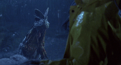 A Person Is Standing In A Dark Room With A Blue Light Behind Them GIF