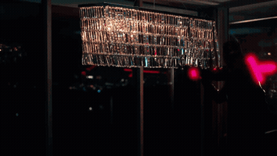 A Person Is Standing In A Dark Room With A Red Light Behind Them GIF