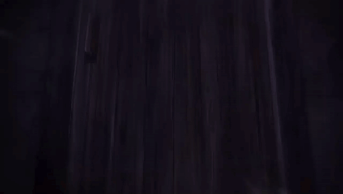 A Person Is Standing In A Dark Room With A Sword In Their Hand GIF