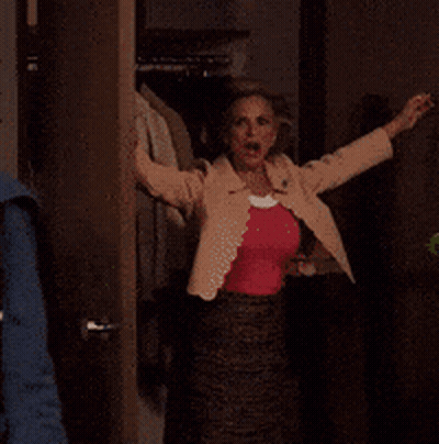 A Person Is Standing In A Doorway With Their Arm Outstretched . GIF