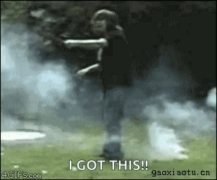 A Person Is Standing In A Field With Smoke Coming Out Of Their Hands And Says I Got This GIF