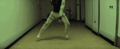A Person Is Standing In A Hallway With Their Legs Crossed . GIF