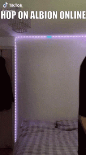 A Person Is Standing In Front Of A Bed With Purple Lights Behind Them And The Words Hop On Albion Online Above Them GIF