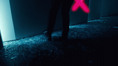 A Person Is Standing In Front Of A Broken Glass Door GIF