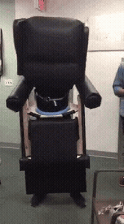A Person Is Standing In Front Of A Chair That Looks Like A Giant Chair GIF