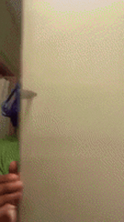 A Person Is Standing In Front Of A Door In A Bathroom . GIF