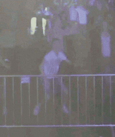 A Person Is Standing In Front Of A Fence With A Fireball Coming Out Of The Fence . GIF