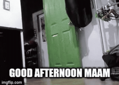 A Person Is Standing In Front Of A Green Door In A Room . GIF