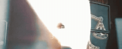 A Person Is Standing In Front Of A Wall With A Light Coming Through It . GIF