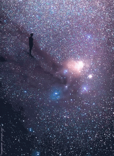 A Person Is Standing In The Middle Of A Galaxy With A Purple Background And A Few Stars GIF